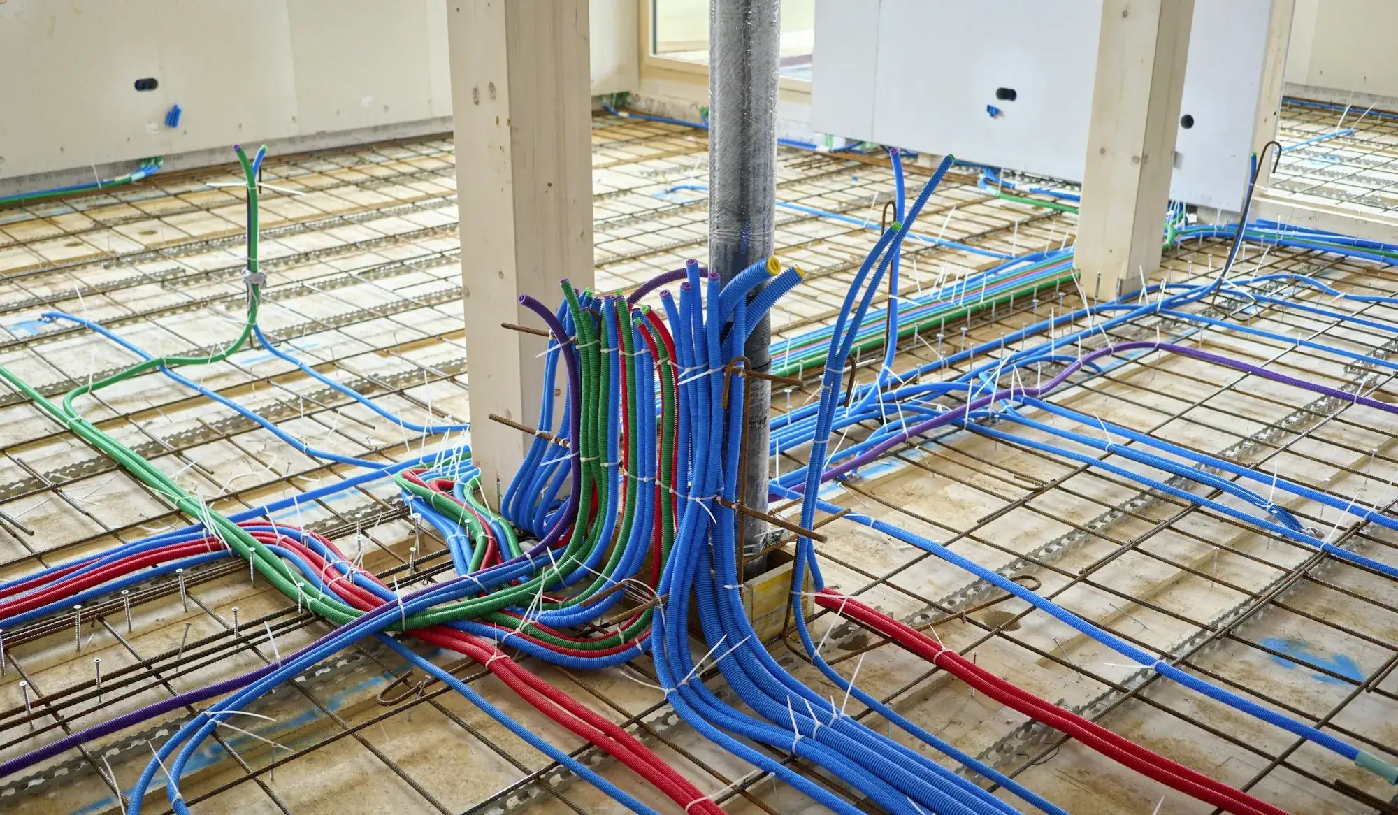 Verlegte Heizungsrohre auf einer Rohbaudecke vor dem Estrich
